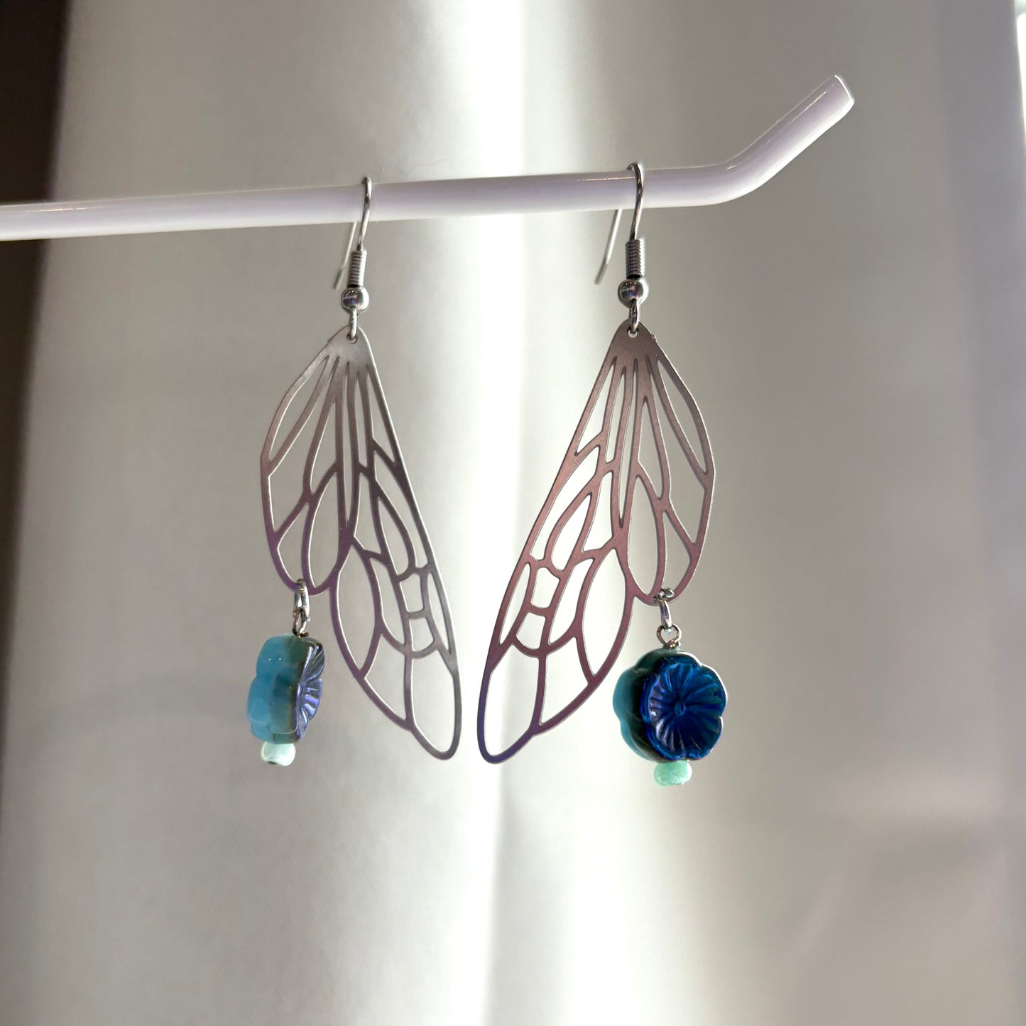 Stainless steel silver fairy wing dangle earrings with blue reversible blue flowers