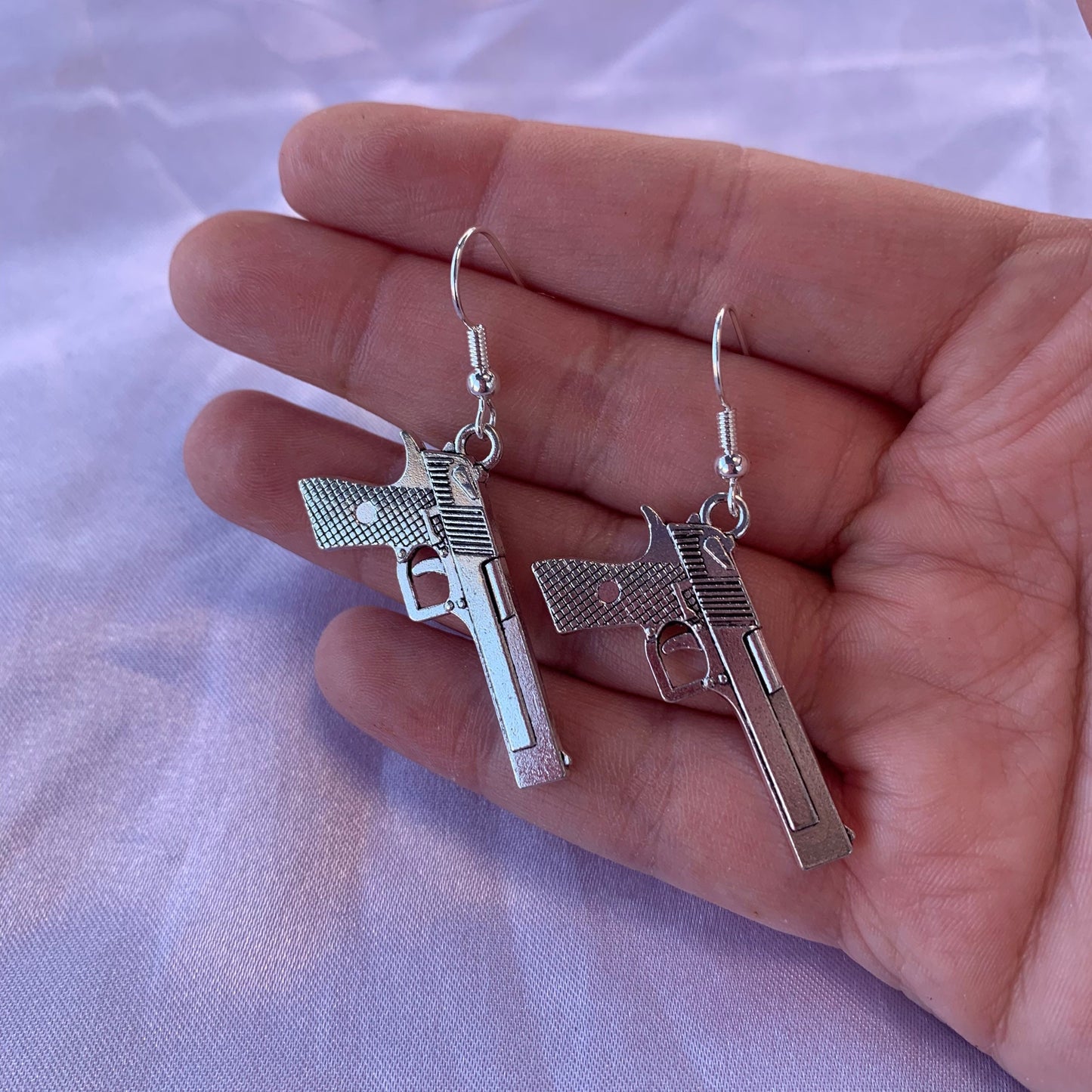 Silver gun dangle earrings